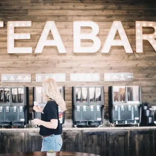 a woman standing in front of a tea bar