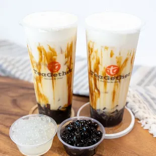 two cups of iced coffee on a wooden tray