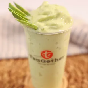 a cup of green tea with a green garnish