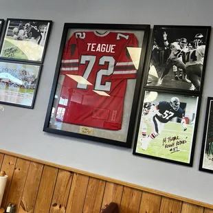 shows a wall of framed football jerseys