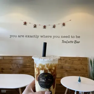 a hand holding a cup of iced tea