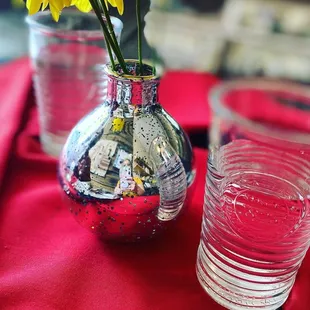 a vase of flowers and a shot glass