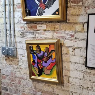 a brick wall with paintings on it