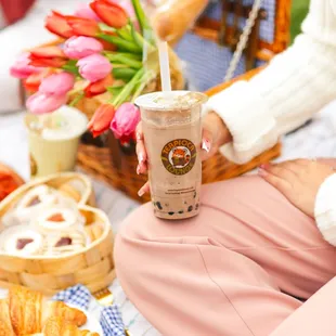 a woman holding a cup of iced coffee