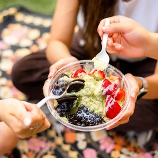 a woman eating a bowl of fruit