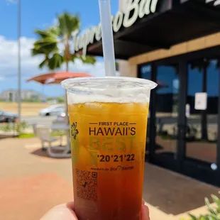 a hand holding a cup of iced tea