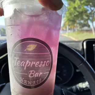 a hand holding a cup of iced tea