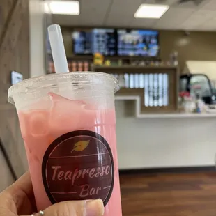 a hand holding a cup of iced tea