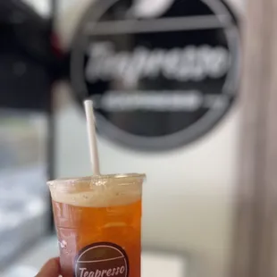 a hand holding a cup of iced tea