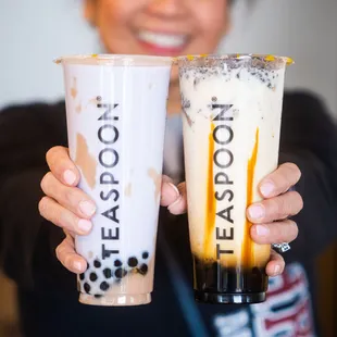 a woman holding two cups of teaspoon