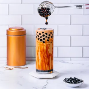 bubble tea being poured into a tall glass