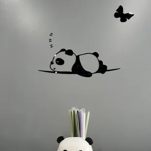 a panda sleeping on a branch with butterflies