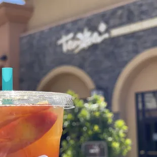 a hand holding a cup of iced tea