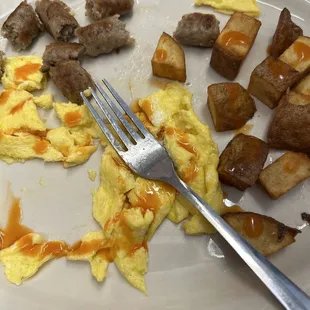 Eggs, Sausage links, and chunky potatoes with hot sauce