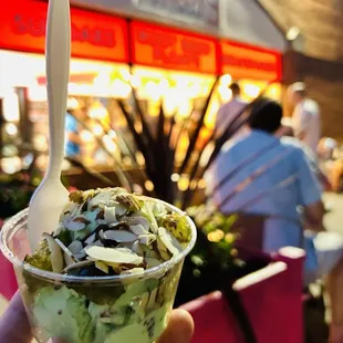 a hand holding a cup of ice cream