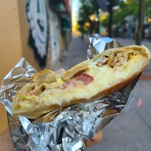 a hand holding a piece of pizza