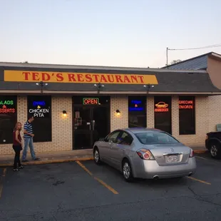 two people standing in front of the restaurant