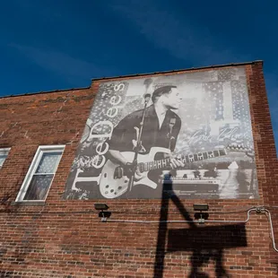 a man playing guitar on the side of a building
