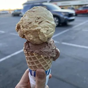 a hand holding a cone of ice cream