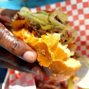 a hand holding a half eaten sandwich