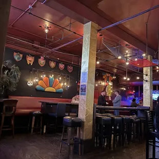 the interior of a restaurant with tables and stools