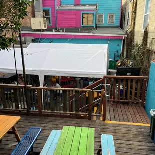 a wooden deck with colorful benches and tables