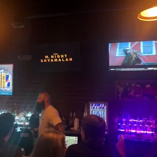 a bar with people watching televisions