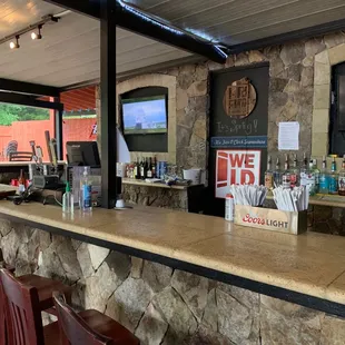 a bar with a stone counter and bar stools