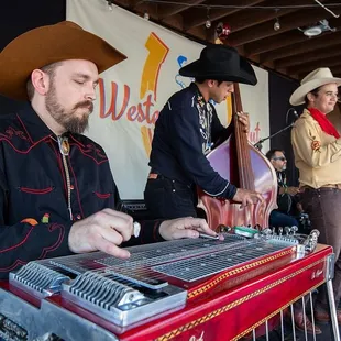 a man in a cowboy hat playing a musical instrument