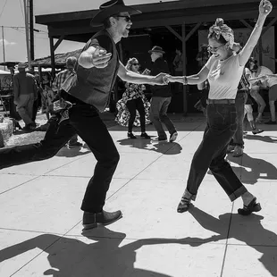 a couple of people dancing on a sidewalk
