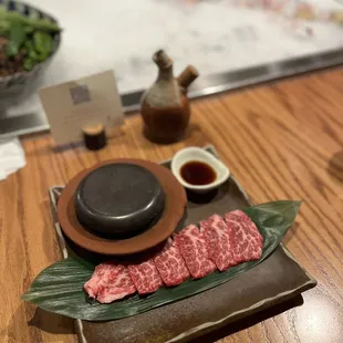 a plate of meat and a bowl of sauce