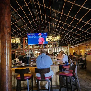 a man sitting at a bar watching tv