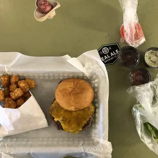 Cheeseburger with tater tots with condiments