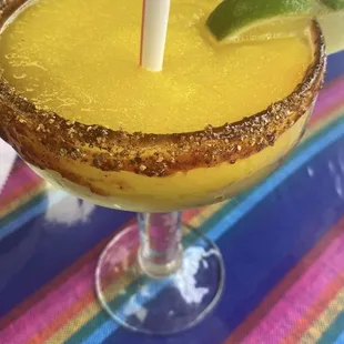 Bomb mango frozen margarita with chamoy y chile tajin rim