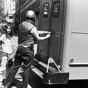 Boy is escorted into paddy wagon.  It is my guess that he was caught breaking windows during an anti-war riot. - - -Tom Brody