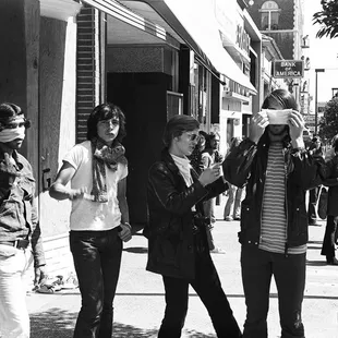 Four rioters posing for my camera.  One  flips the bird at me.  Other puts a napkin over his face to conceal himself.  - - -Tom Brody