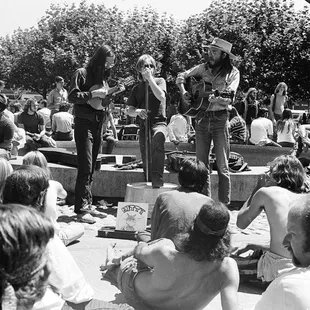 Bluegrass trio with open mandolin case for donating money.  Sign reads KITTY. ----Tom Brody