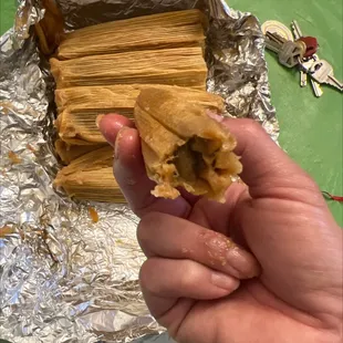 a hand holding a tamales