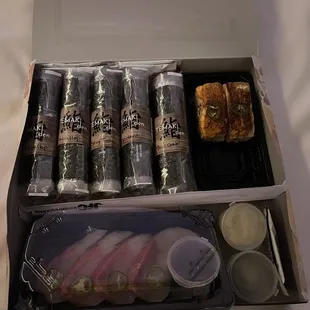 Our rolls individually wrapped &amp; labeled. Right- Salmon Oshizushi, bottom- Hamachi Sashimi.