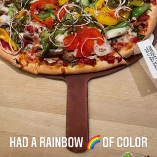 Lots of veggie pizza with sausage and sun dried tomatoes.