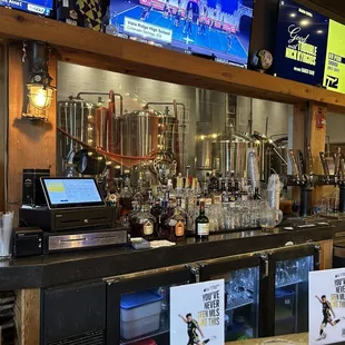 Picture of the bar with the brewery behind the glass.
