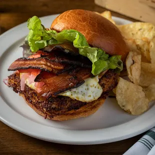 a bacon and egg sandwich with chips