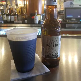 a bottle of beer and a blue cup