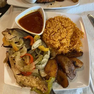 a plate of food with rice, meat, and vegetables