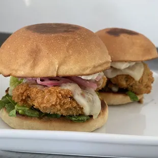 two fried chicken sandwiches on a white plate