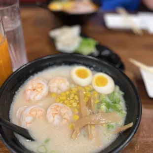 a bowl of ramen with shrimp and eggs