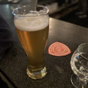 a glass of beer on a bar