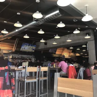 people sitting at tables and watching televisions