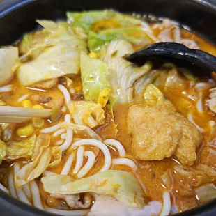 a bowl of soup with chopsticks