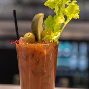 a bloody drink with olives and celery